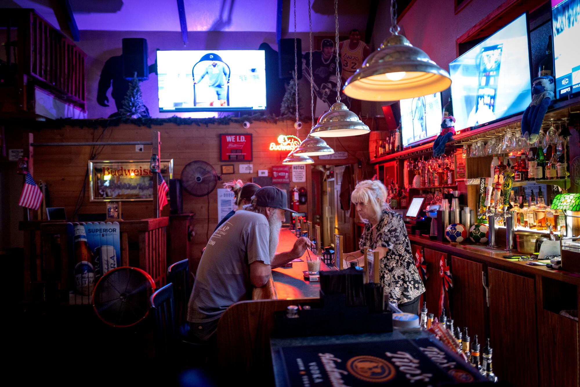 Un barman discute avec les clients du Wrightwood Inn.