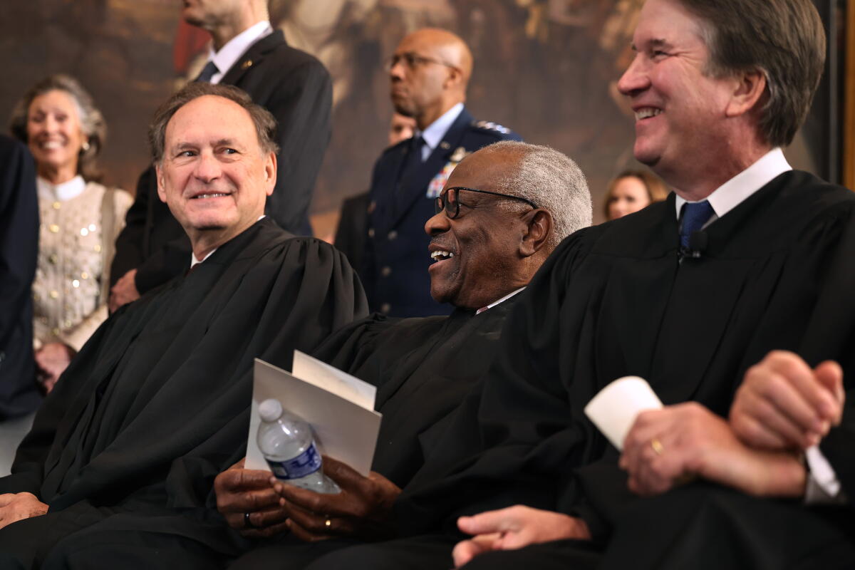 Les juges associés de la Cour suprême Samuel Alito, Clarence Thomas et Brett Kavanaugh partagent un rire