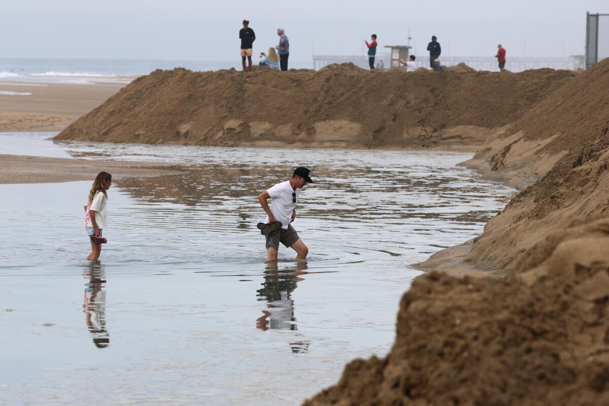 Mike Carter et sa fille Ellie Carter, 11 ans, pataugent dans l'eau de l'océan qui a déferlé sur la plage de Newport Beach.