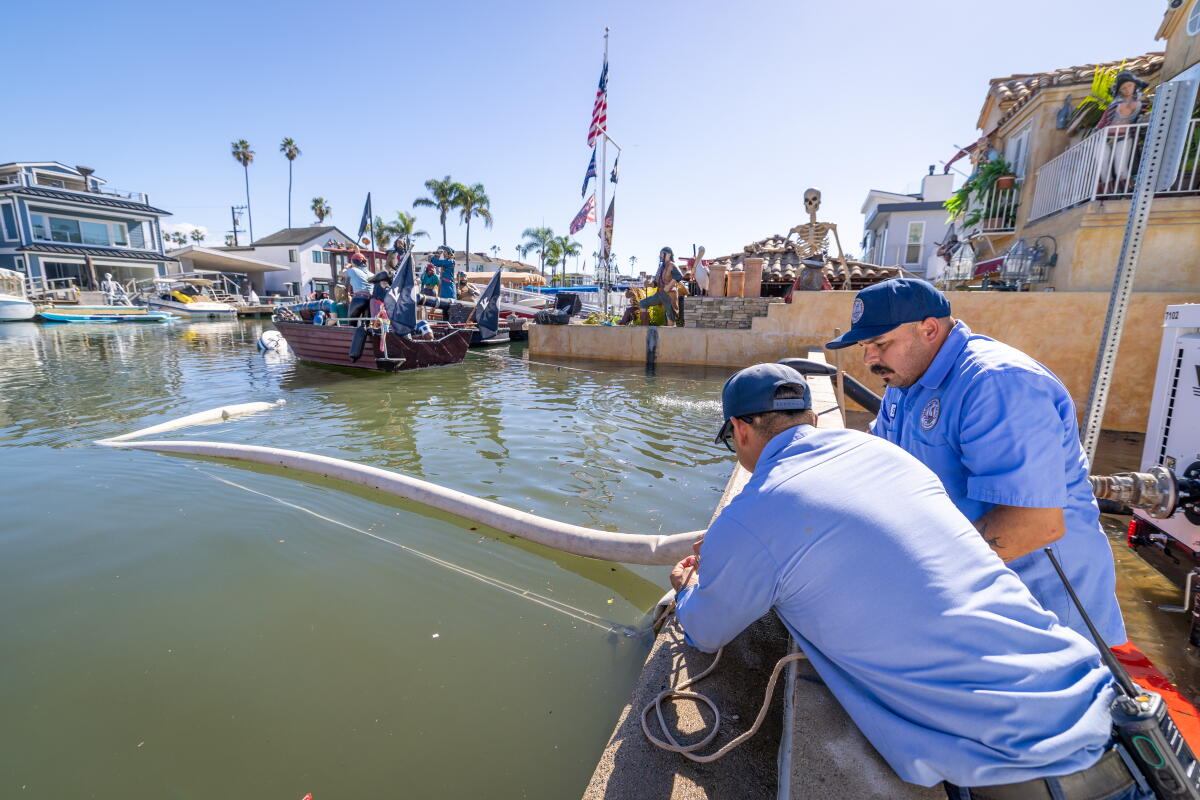 Les employés du département des services publics de Newport Beach pompent l'eau des rues inondées de la péninsule de Newport Beach.